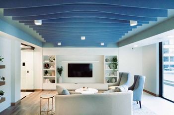 a living room with a blue ceiling and white furniture